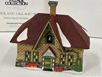 Front view of Apple Valley School figurine with box in background