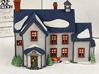 Front view of porcelain farmhouse with snow accents and box partially visible
