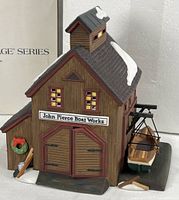 Front view showing sign, double doors, boat on cradle, wreath and oar