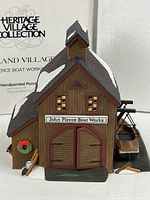 Front view of porcelain boathouse showing sign, doors, side docked boat