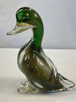 Full profile view of Murano glass duck showing green head, clear body with gold flecks