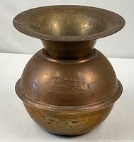 Full view of copper spittoon showing shape and embossing