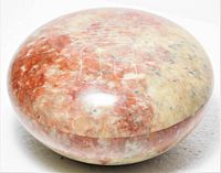Side view of closed round soapstone box showing colour and finish