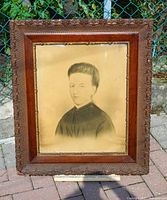 Frontal view of framed portrait showing carved frame and overall appearance