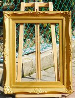 Front view of gold ornate frame showing decorative gesso corners and gold finish