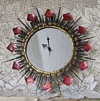 Full view of starburst mirrored wall clock showing overall design and hands