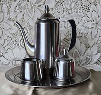 Coffee pot, creamer and covered sugar bowl on round tray