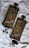 Front view of both sconces showing scrollwork, mirror panels and candle dishes