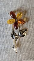 Front view showing floral design, mixed amber petals, silver stem and leaves