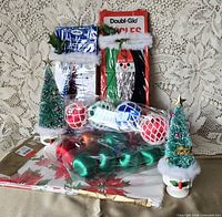 Full lot showing candle holders, tinsel boxes, ornaments, tablecloth