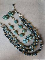 All items laid out: necklace, bracelet, both earring styles