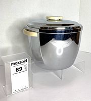 Front view of chrome ice bucket with lid on and Bakelite handles visible