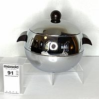 Front view of chrome Penguin ice bucket on stand showing embossed penguins and Bakelite handles/knob