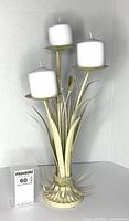 front view of metal cattail candle holder with three candles