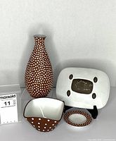 front view of all four ceramics showing vase, bowl, dish and underside of platter