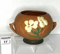 Front view of Roseville pottery jardiniere showing floral motif and handles