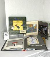 All three books displayed, front book open showing postcard feature