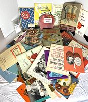 Lot overview showing pile of vintage cooking booklets with various titles
