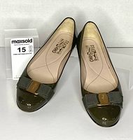 Top view of both shoes showing patent leather, bows, plaques, insoles