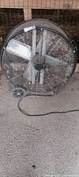 Frontal view of 32" Maxx Air Pro floor fan showing four blades, cage, wheels and cord