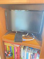 Front view of Insignia flat screen TV on shelf