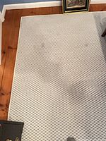 Top view of rug corner showing cream base and blue diamond pattern