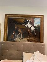 Full view of framed dog painting resting against headboard