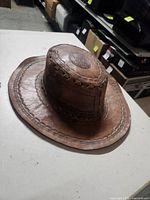 Full view of brown leather cowboy hat showing brim and crown