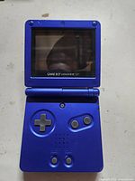 Front view of closed Game Boy Advance SP showing color and screen damage