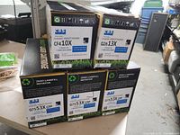 Front view showing model stickers CF410X, Q2613X and Q7553X on five boxes