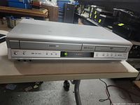 Front view of Toshiba VCR/DVD combo showing VHS and DVD sections, display, buttons