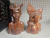 Front view of both Balinese wood bust statues