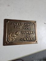Front of brass plaque showing text, graphic, mounting holes
