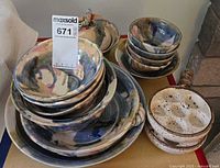 Overall view of stacked Baily Brown stoneware bowls, plates and escargot dishes