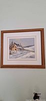 Full view of framed winter landscape painting on wall