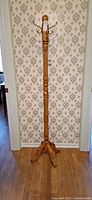 Full view of wooden hall tree with hooks and base
