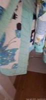 Full view of quilt showing butterfly appliqué blocks and aqua border