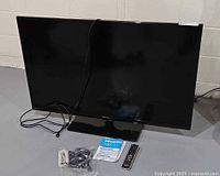 Front view of Hisense 50-inch TV with accessories laid out