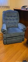 Front view of blue La-Z-Boy recliner showing tufted back, padded arms, skirted base