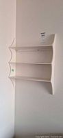 Front view of white two-tier wall shelf mounted on wall
