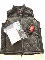 Full view of black Milwaukee heated vest with charger, battery and manual
