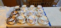All 12 teacup and saucer sets displayed on counter