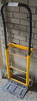 Full view of folded hand truck showing frame, handle and wheels