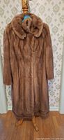 Front view full-length mink fur coat on stand