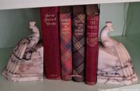 Pair of marble peacock bookends with four books between them