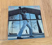 Front album jacket depicting artist outside glass house