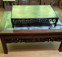 Coffee table with tray on top, showing carved sides and marble panel