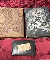 All three books laid out on fabric: two large albums and one small autograph book