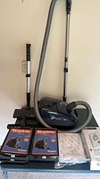 SEBO canister vacuum assembled with hose and wand, two Simplicity bag boxes, SEBO service box and sealed bag pack
