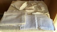 Stack of folded linens including tablecloths, blanket, napkins